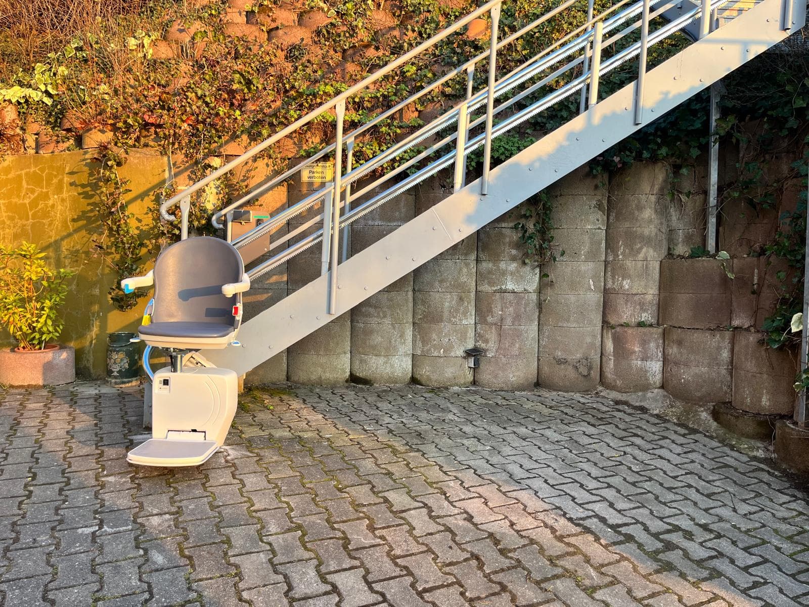 Außen-Sitzlift an einer Metall-Außentreppe am Hauseingang