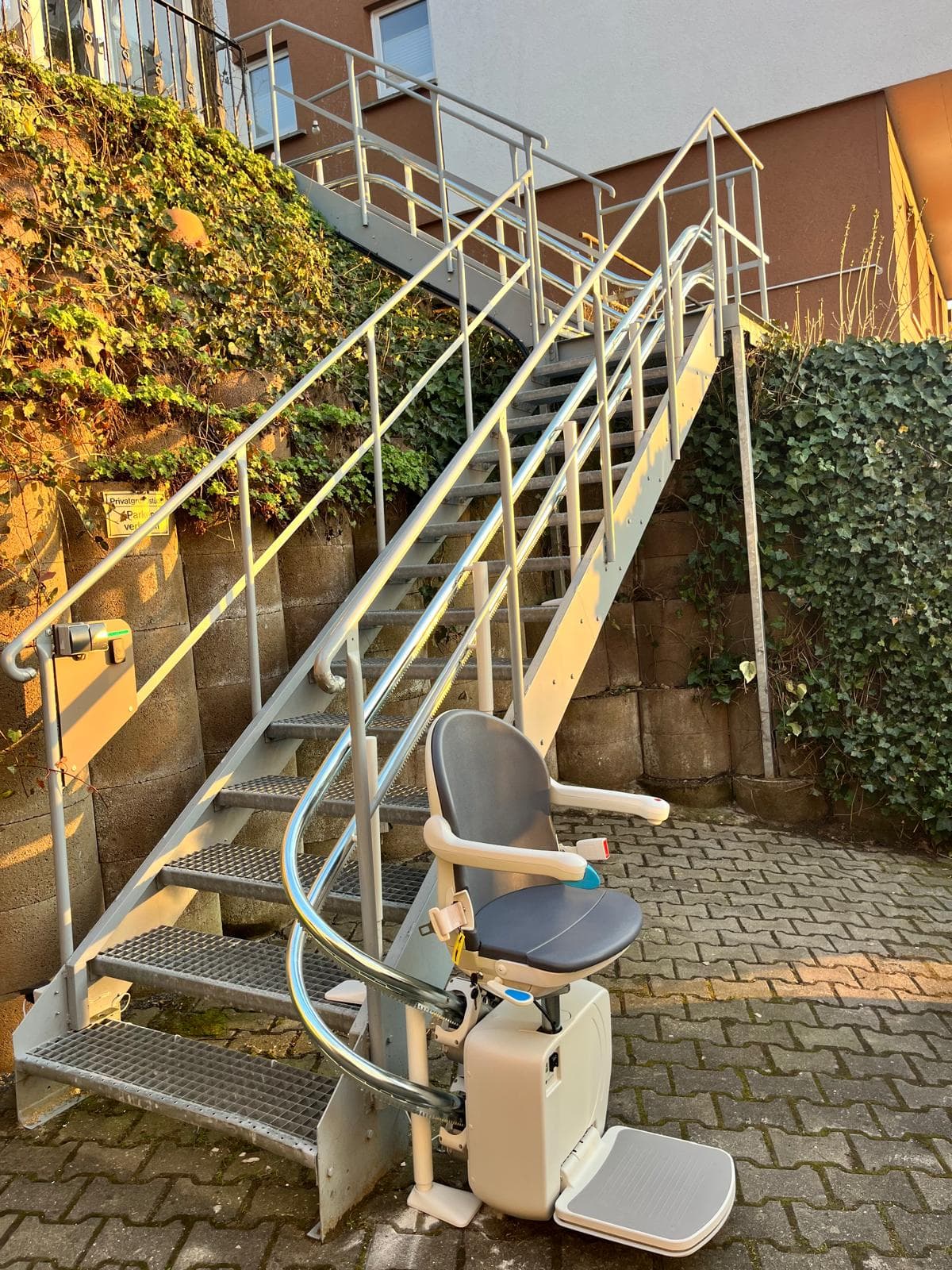 Außen-Treppenlift an einer Stahltreppe am Hauseingang